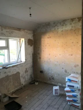 Before: a room with damp-stained, blown plaster on the walls