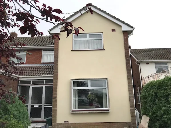 The same house rendered and finished cream across the front elevation and the gable