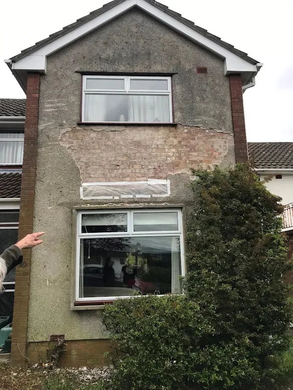 The house before, the old finish stained and breaking up around the windows