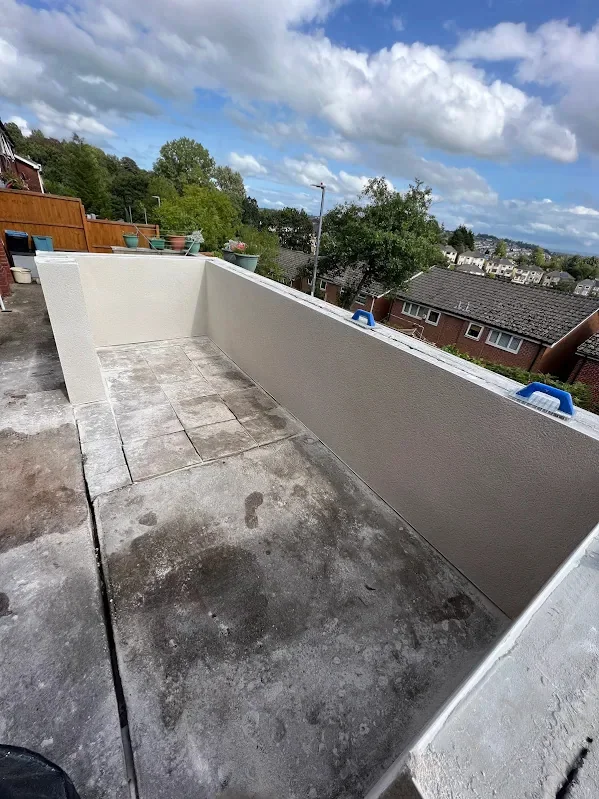 Balcony parapet rendered smooth on a flat roof terrace above the rooftops