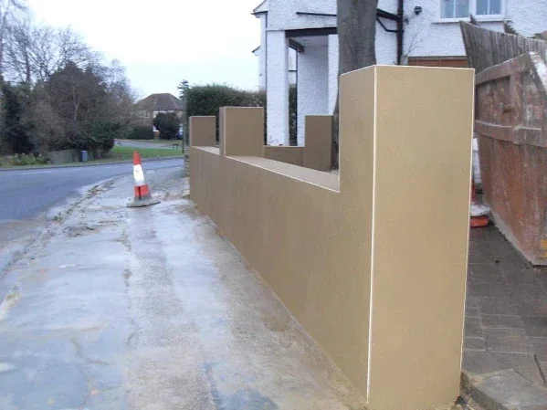 The same boundary wall from the footway, the top line kept level