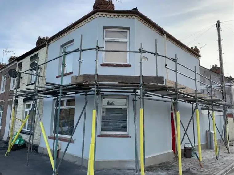 End-terrace on the corner, scaffolded and part-rendered part way through the job