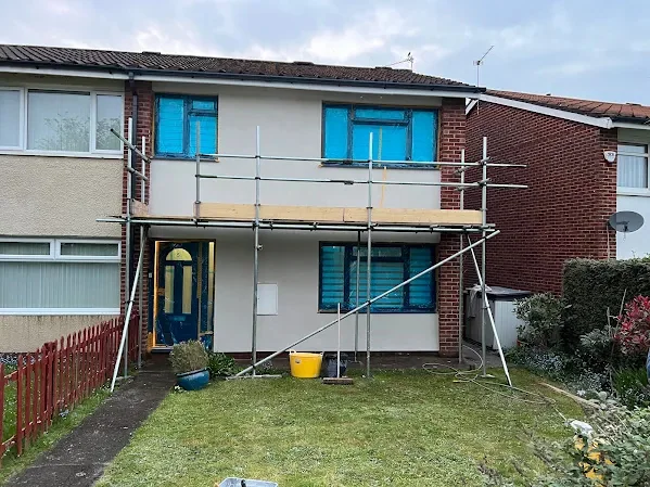 Front of a semi rendered cream, scaffold still across the elevation