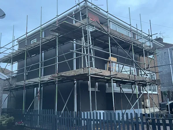 House fully scaffolded and sheeted while the render goes on