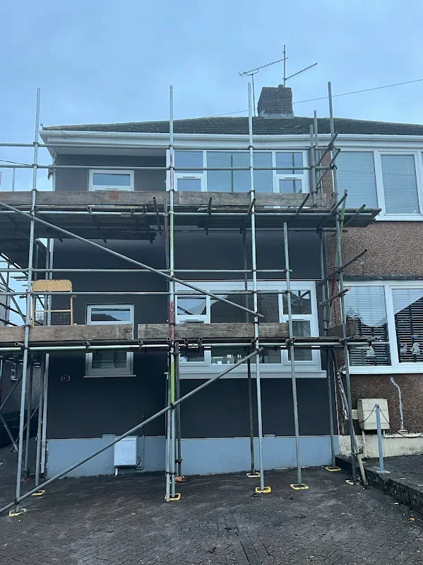 Semi sheeted and scaffolded with the render going on behind it