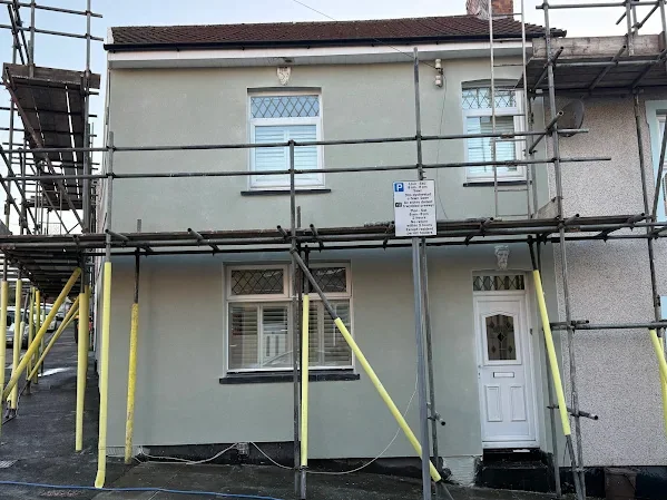End of terrace rendered cream, propped scaffold across the front