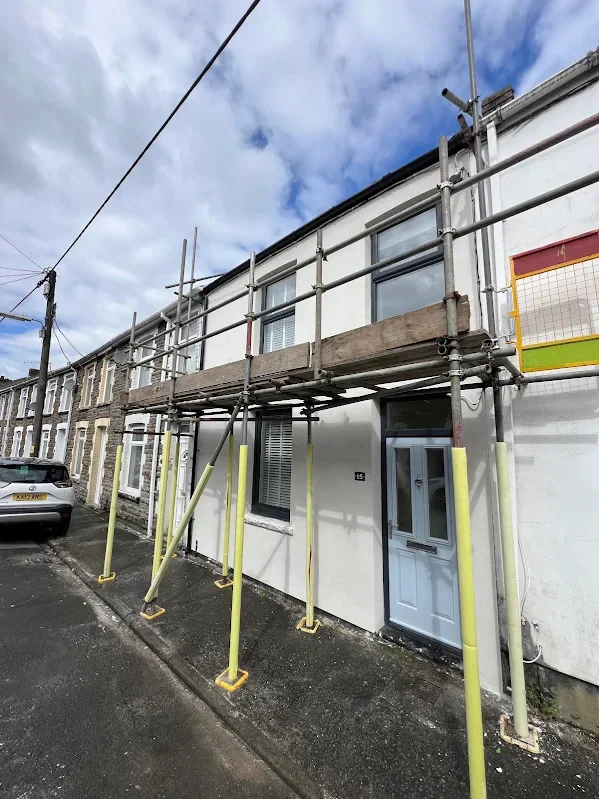 Render going on a run of terraces, propped scaffold the length of the front