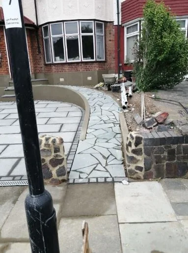 Rendered front wall with new stone edging and a paved path