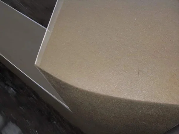 Close-up of the top of a rendered wall, the arris run straight along its length