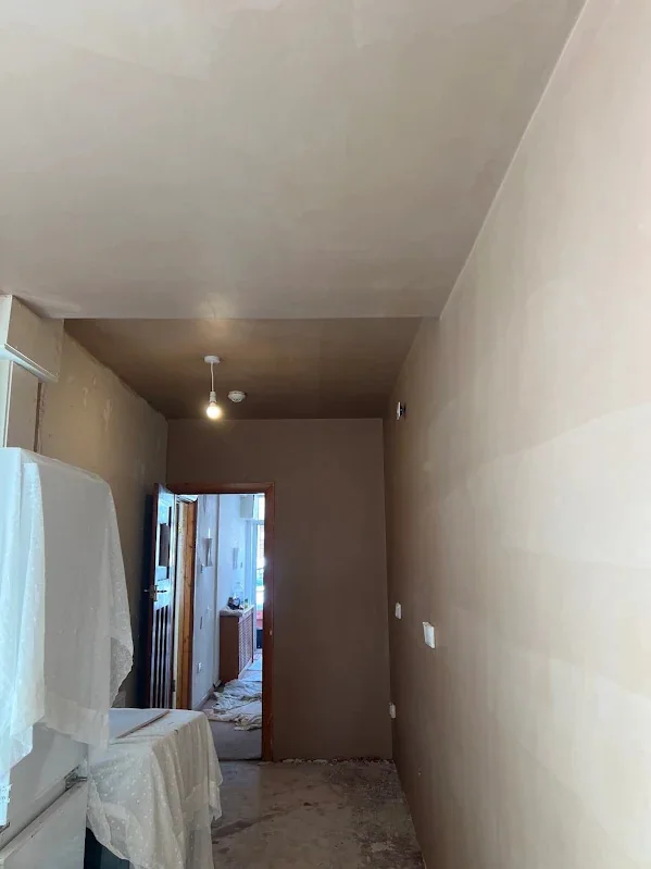 Hallway skimmed through to the front door with the floor still covered